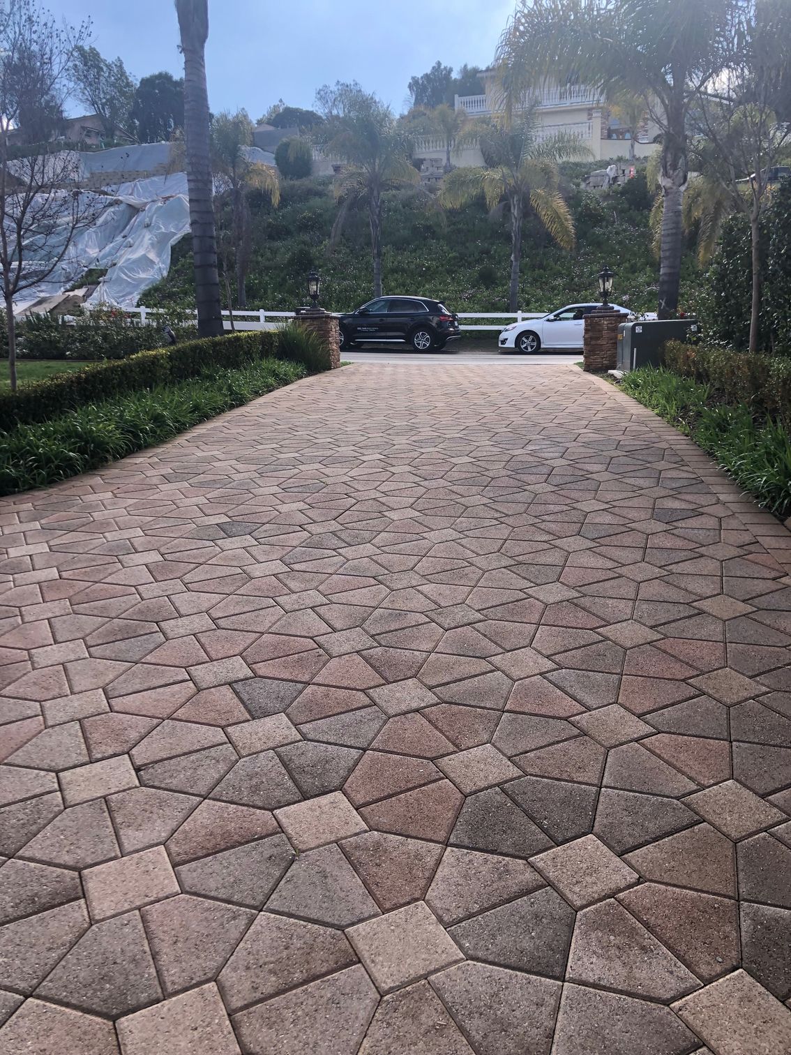 A couple of men are working on a brick walkway.