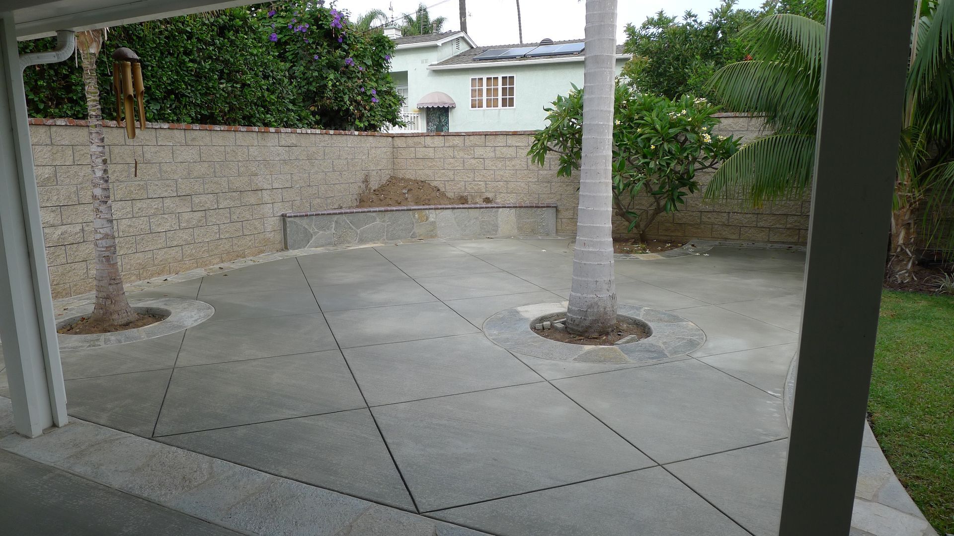 A construction worker wearing orange gloves is pouring concrete on a construction site.