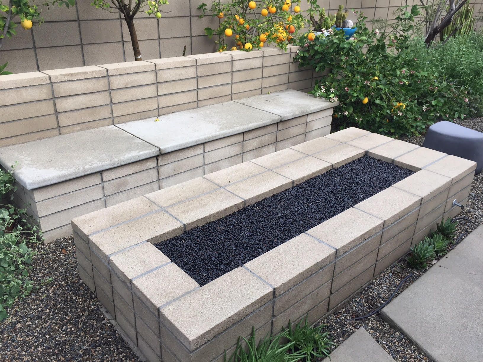 A construction worker is kneeling down on a brick walkway.