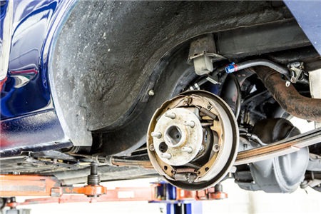 A blue car is sitting on a lift in a garage.