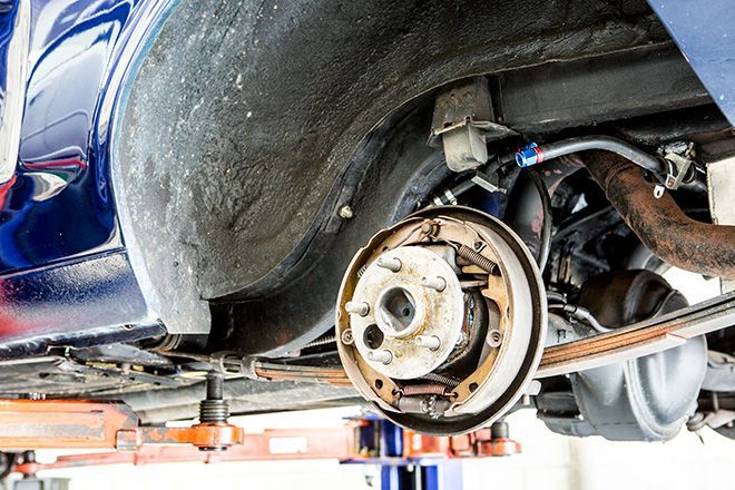 A car is being repaired on a lift in a garage.
