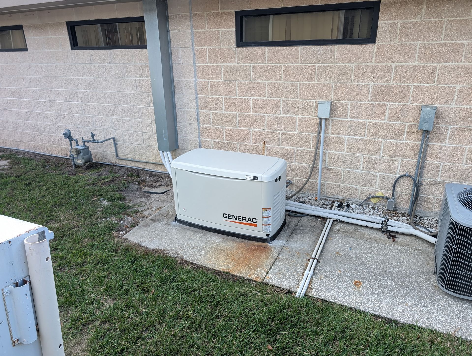 Man starting a red generator next to a white RV, person looks out the door, sunny outdoor setting. Man starting a red generator next to a white RV, person looks out the door, sunny outdoor setting.