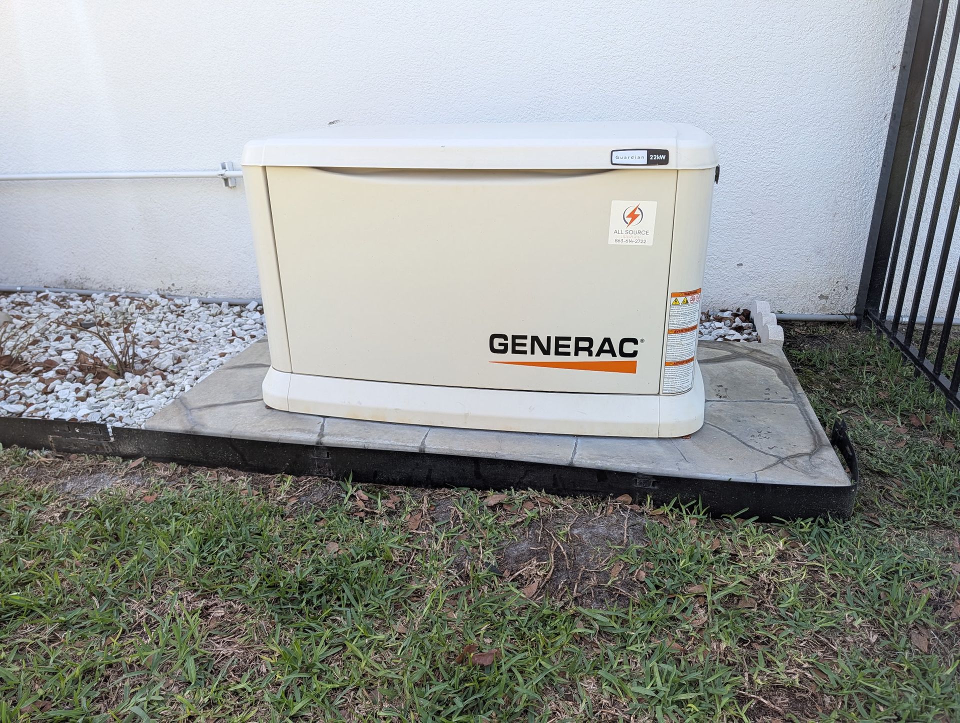Man in a light blue shirt inspecting blue machinery, holding a clipboard and pen.