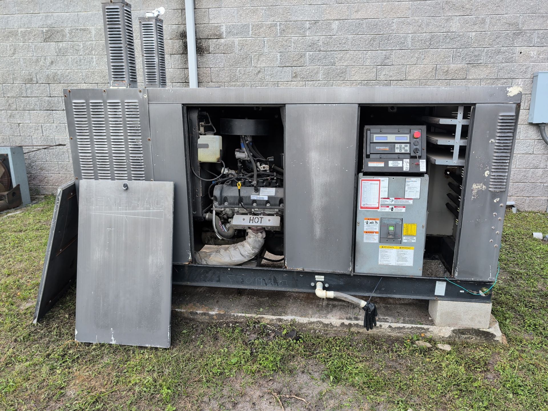 Orange and black generator on cobblestone with wooden structures in the background.