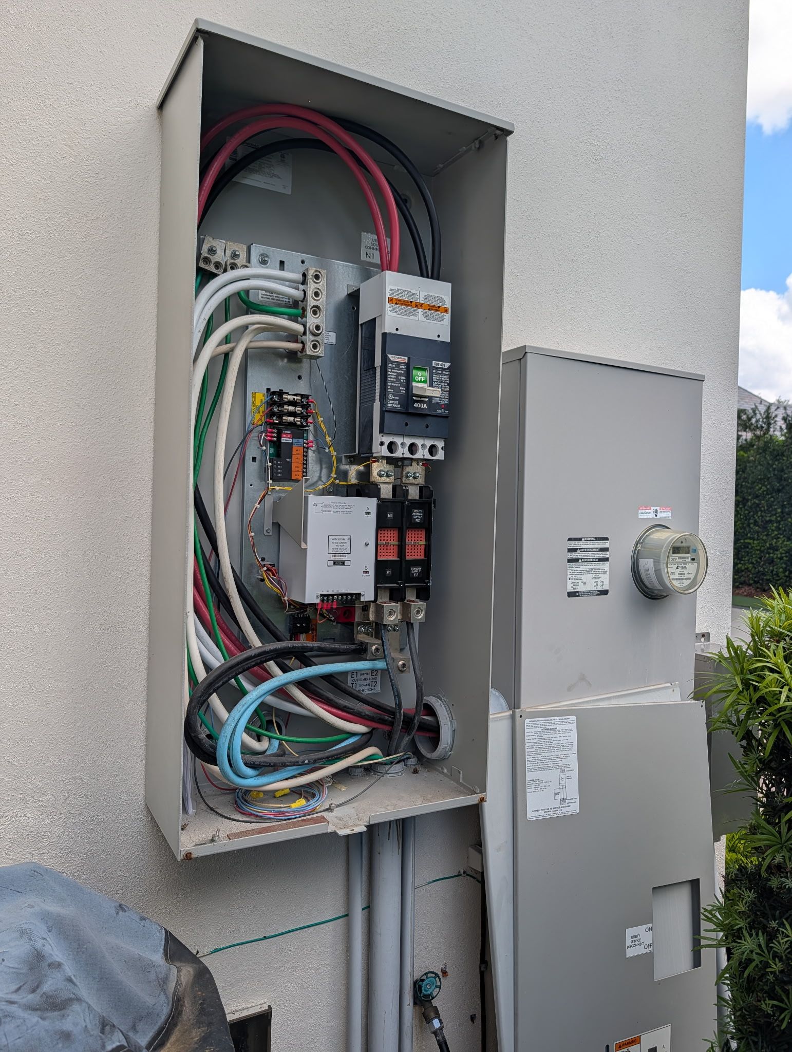 Person in blue sweatsuit pulls a blue generator with a handle across a concrete floor.