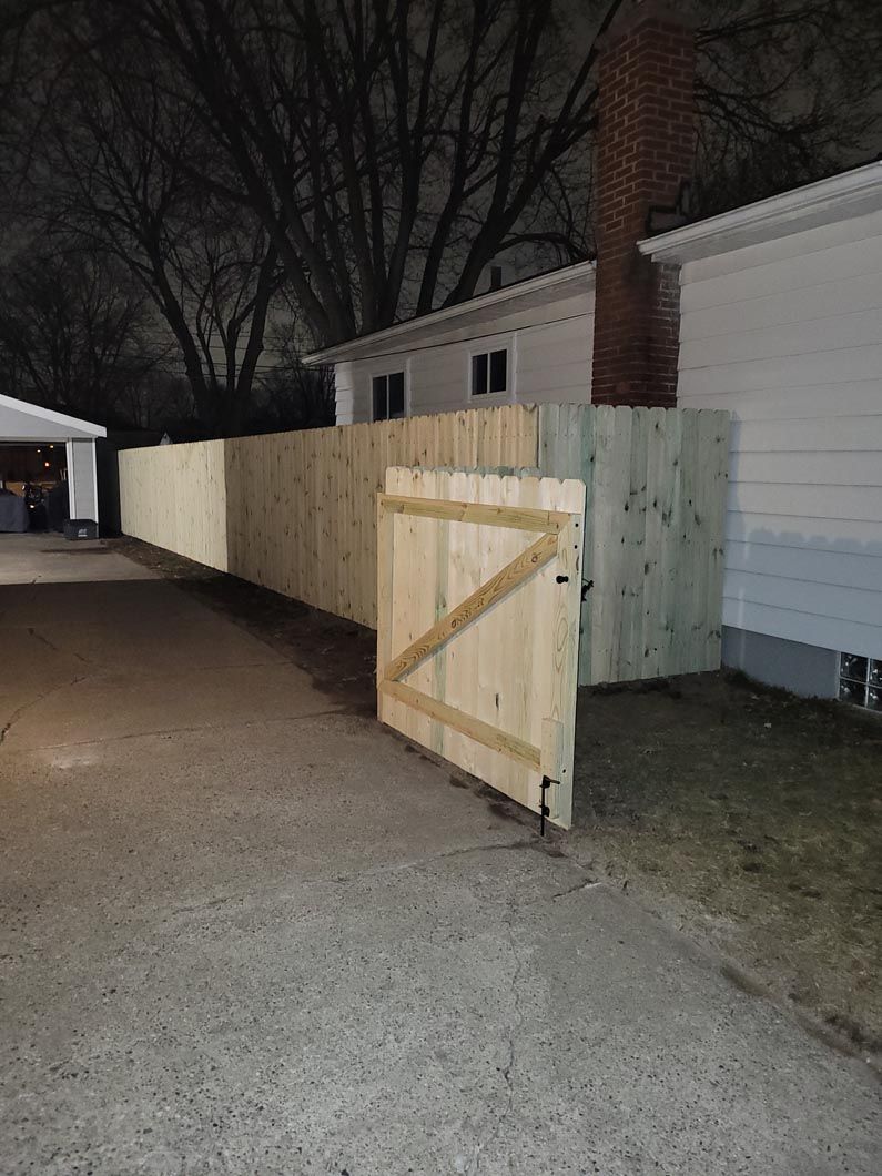 A wood fence in Troy, MI in a backyard in by Elite Wood Fencing