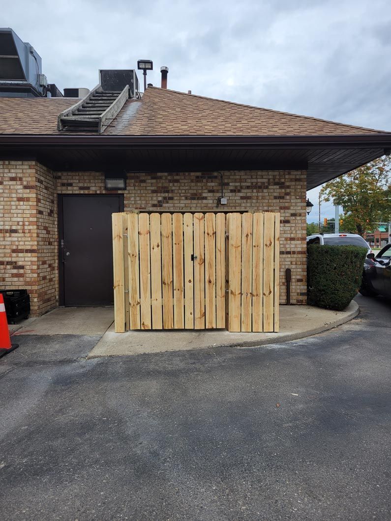 A dumpster enclosure in Troy, MI in a backyard in by Elite Wood Fencing