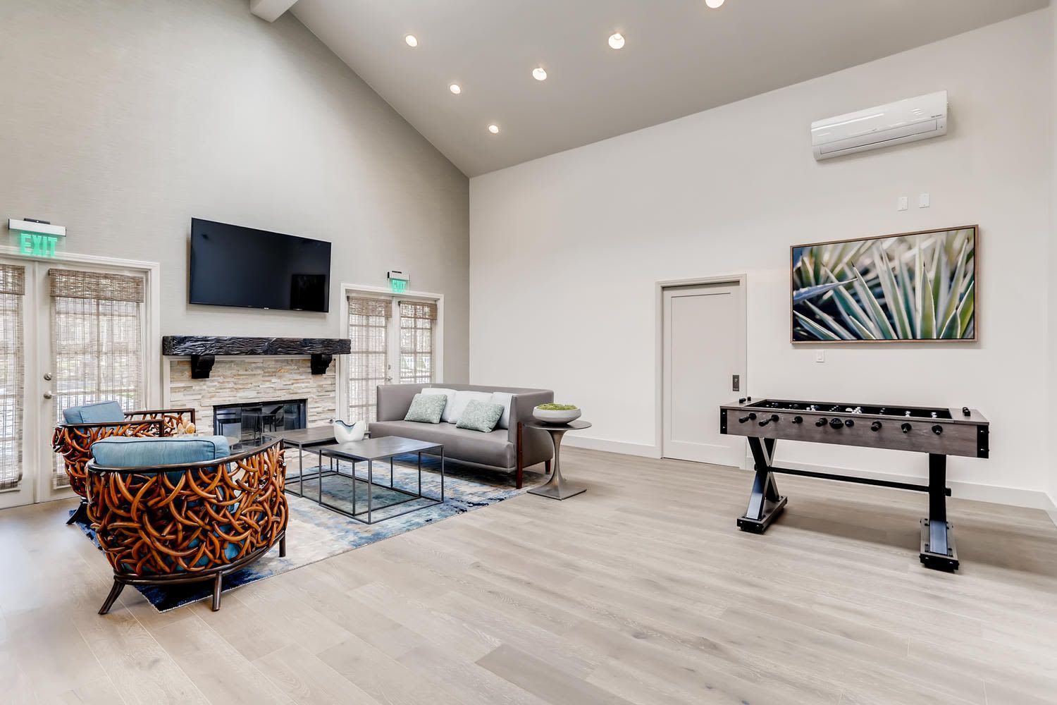 Spacious communal lounge with sofa, chairs, fireplace, large TV, and a foosball table.