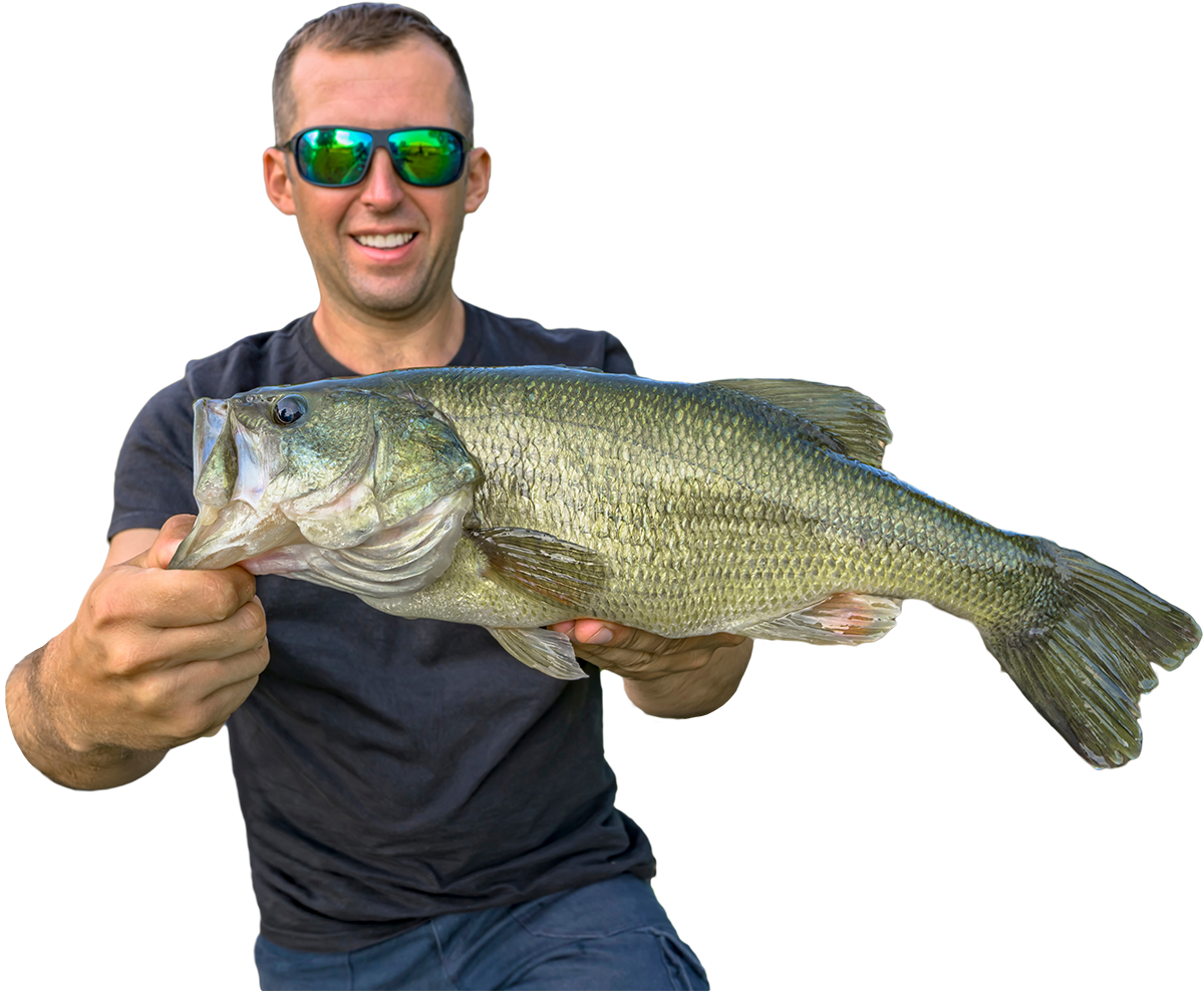 A man wearing sunglasses is holding a large fish in his hands.