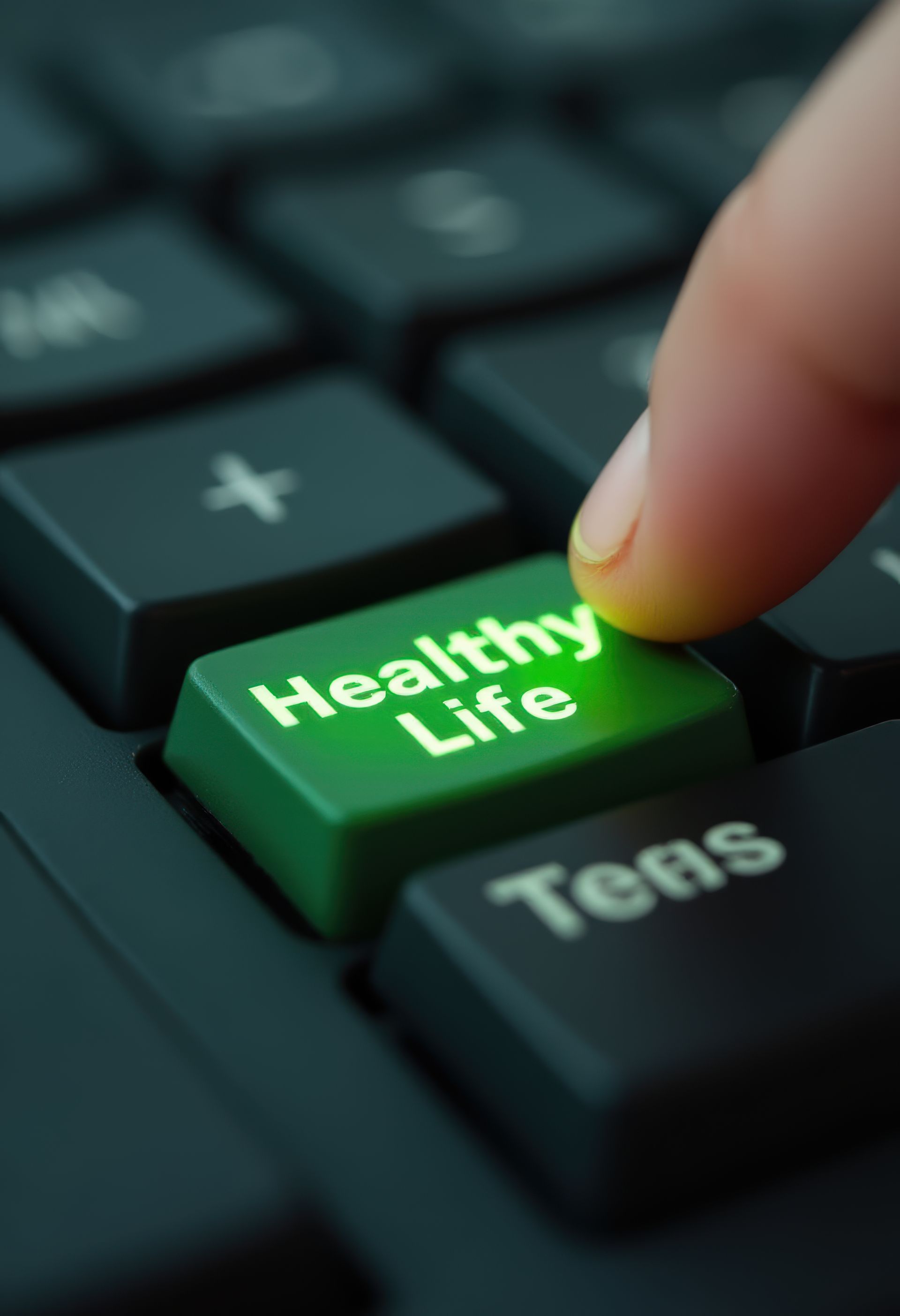 Finger pressing a glowing green "Healthy Life" keyboard button.