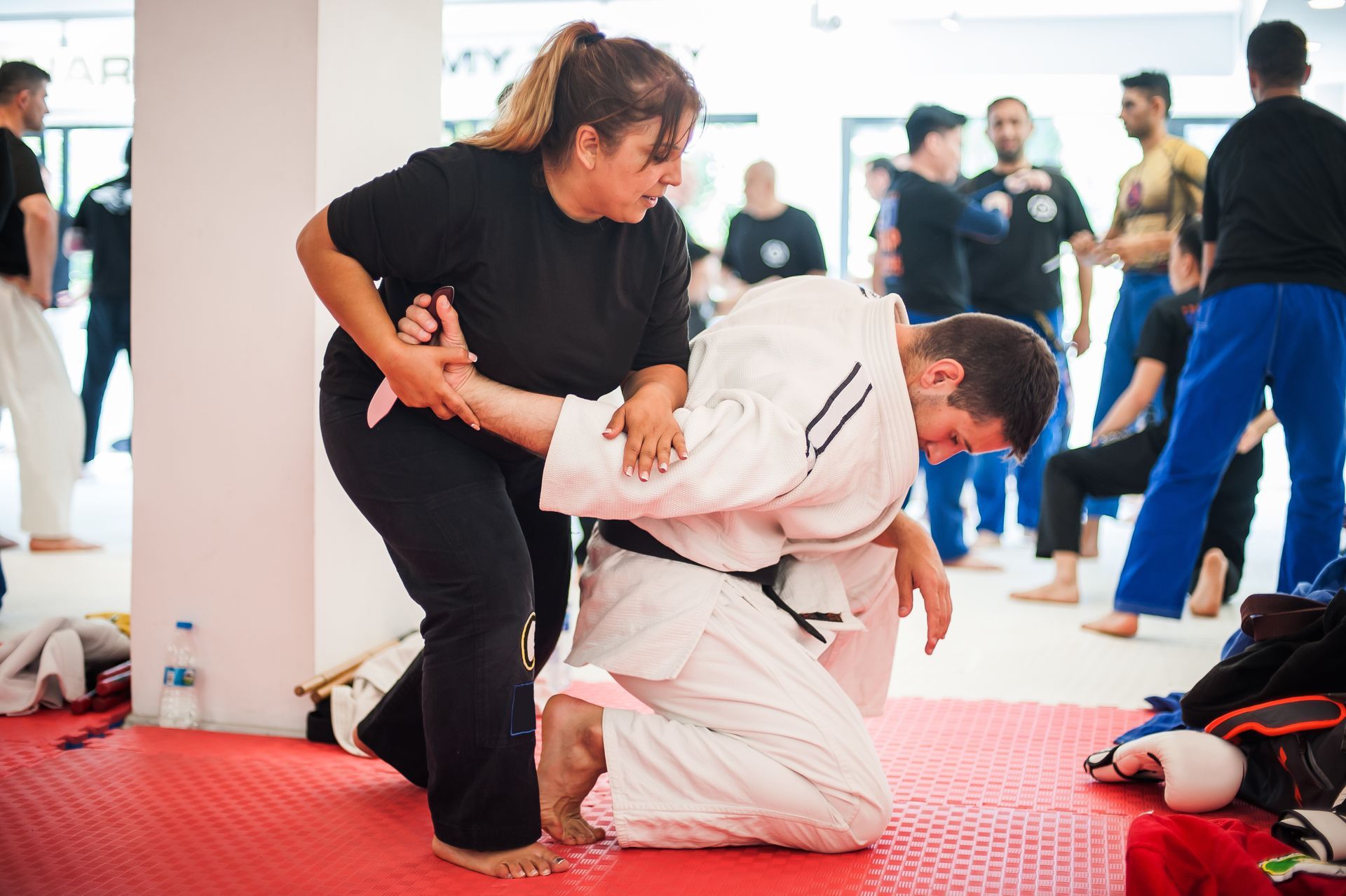 A student practicing a joint-lock technique with an instructor during a self-defense class. A student practicing a joint-lock technique with an instructor during a self-defense class.
