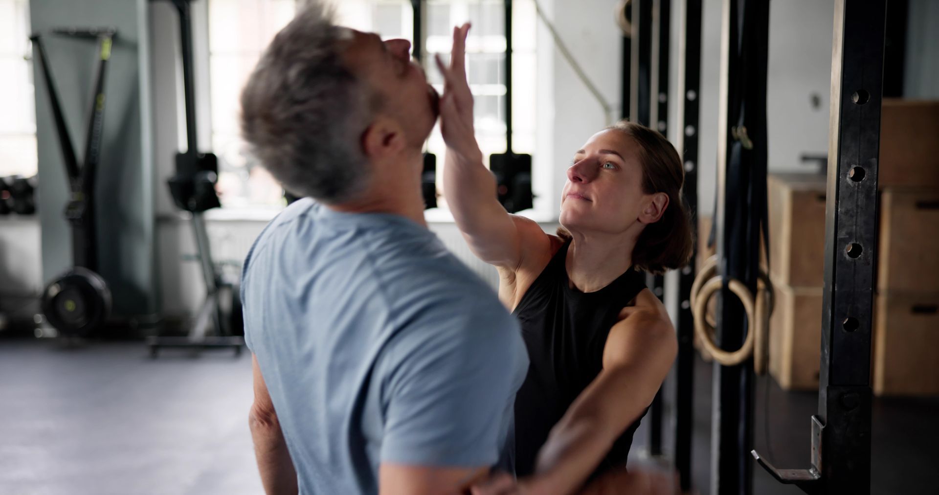 A woman in a self-defense class with a personal trainer.