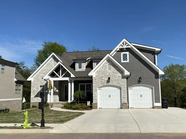 A large house with two garages and a mailbox in front of it