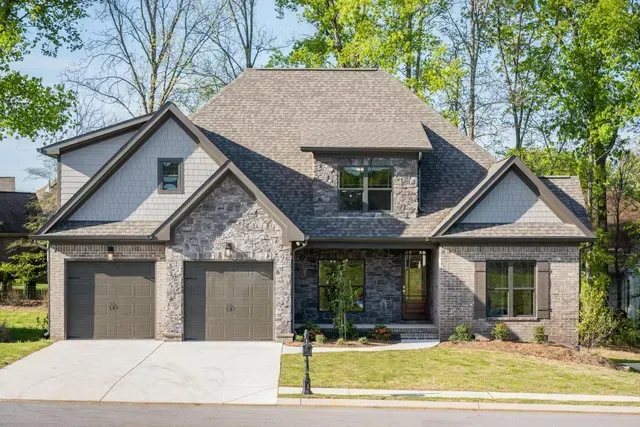 A large brick house with two garages and a driveway.