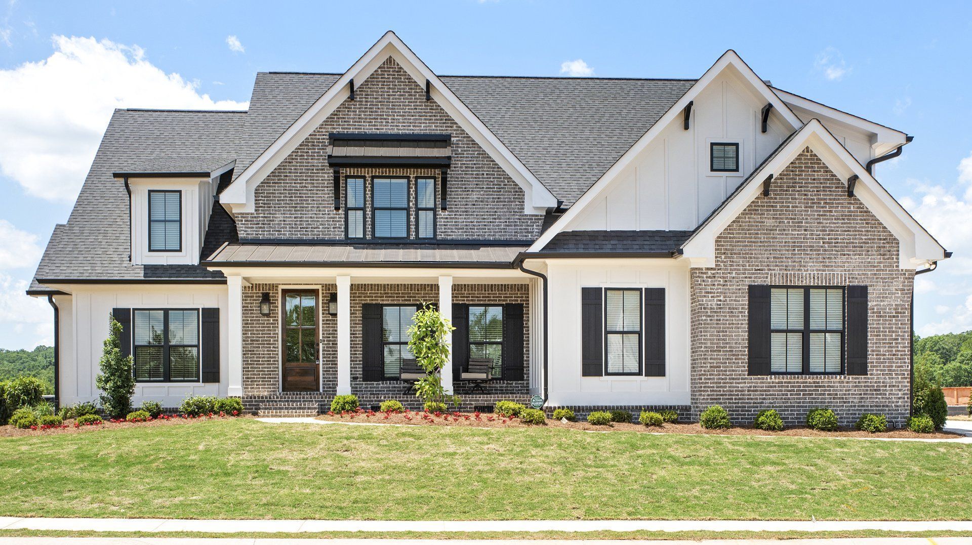 A large brick house with a black roof and black shutters
