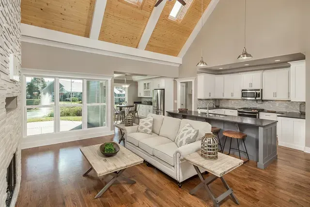 A living room with a couch , coffee table , and kitchen.
