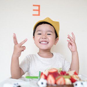 A little boy wearing a yellow hat with the letter e above his head