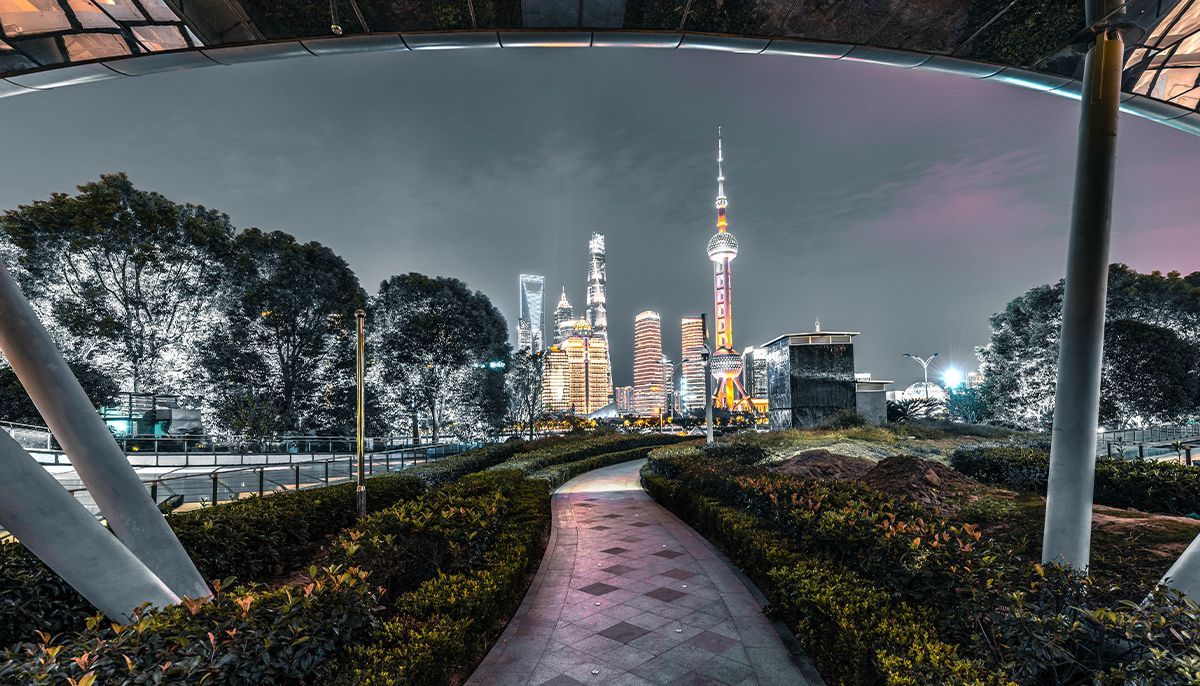 A path leading to a city skyline at night.