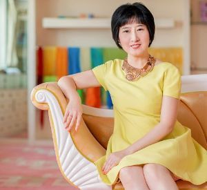 A woman in a yellow dress is sitting on a couch.