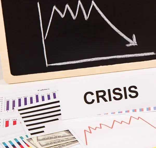 A chalkboard with a graph and the word crisis on it