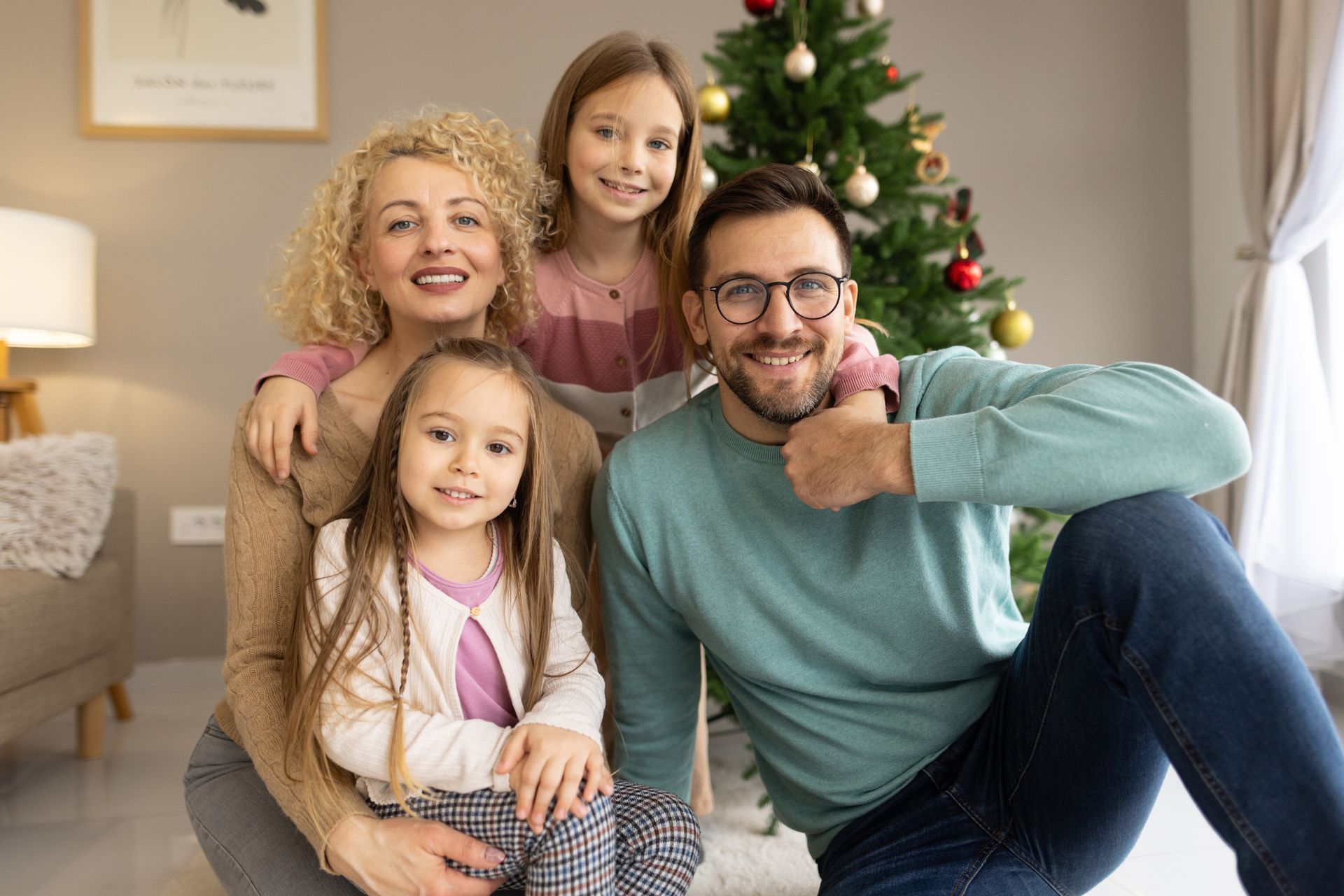 Person in suit protecting a wooden family cutout with hands, on a wooden table. Blue background.
