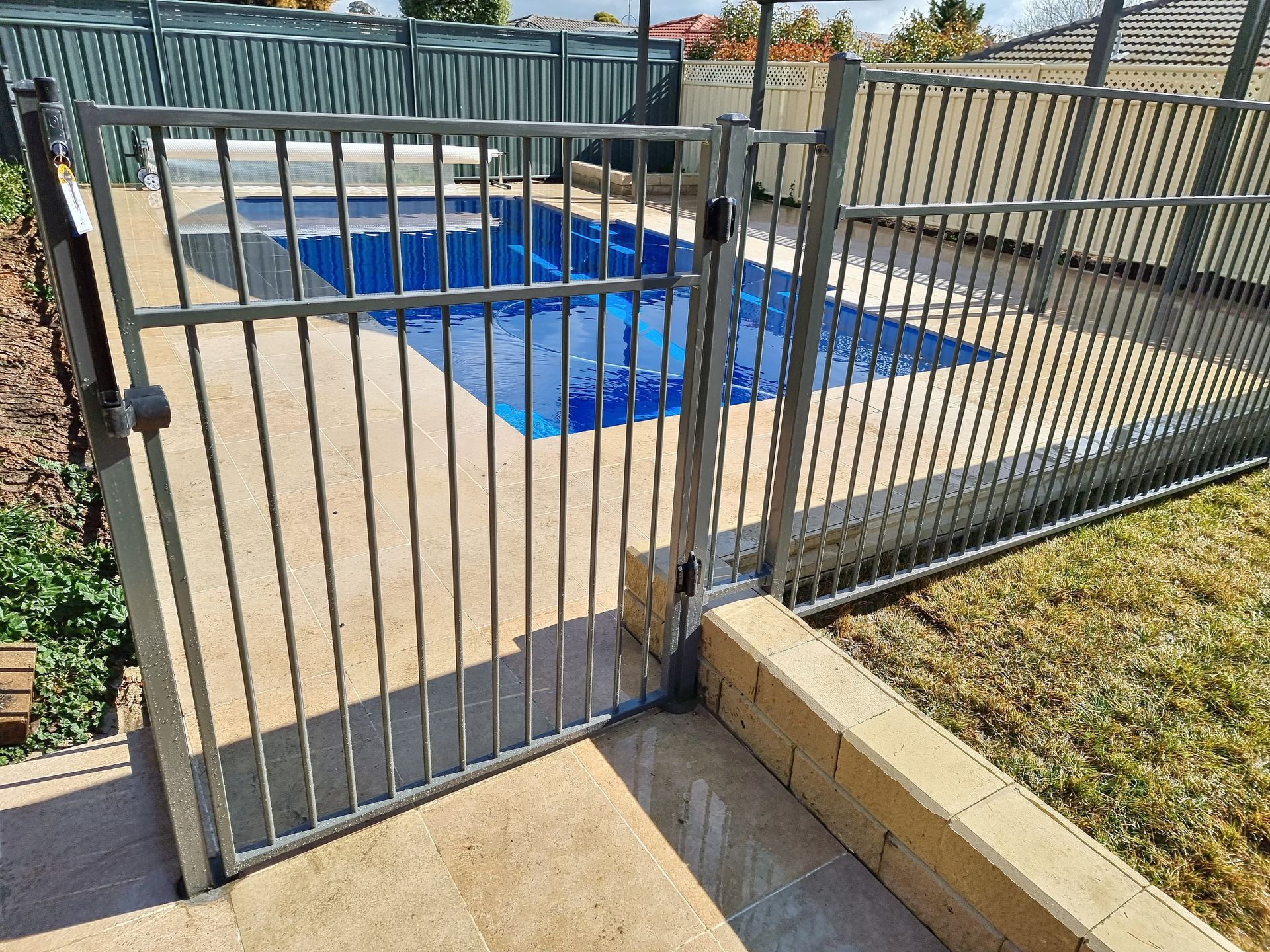 A Large Swimming Pool Is in The Backyard of A House  — GnB Fencing and Excavation in Queanbeyan, NSW