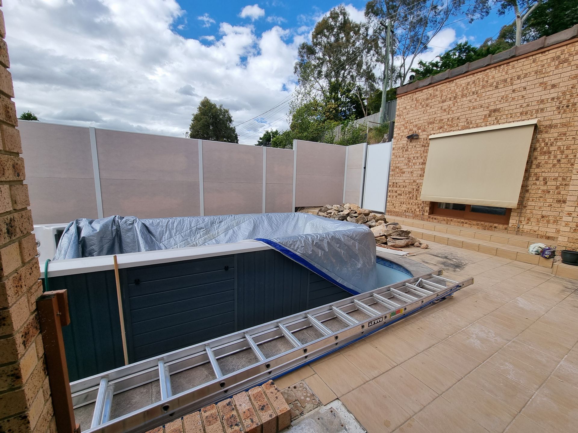 A Brick Building with A Gate in Front of It  — GnB Fencing and Excavation in Queanbeyan, NSW