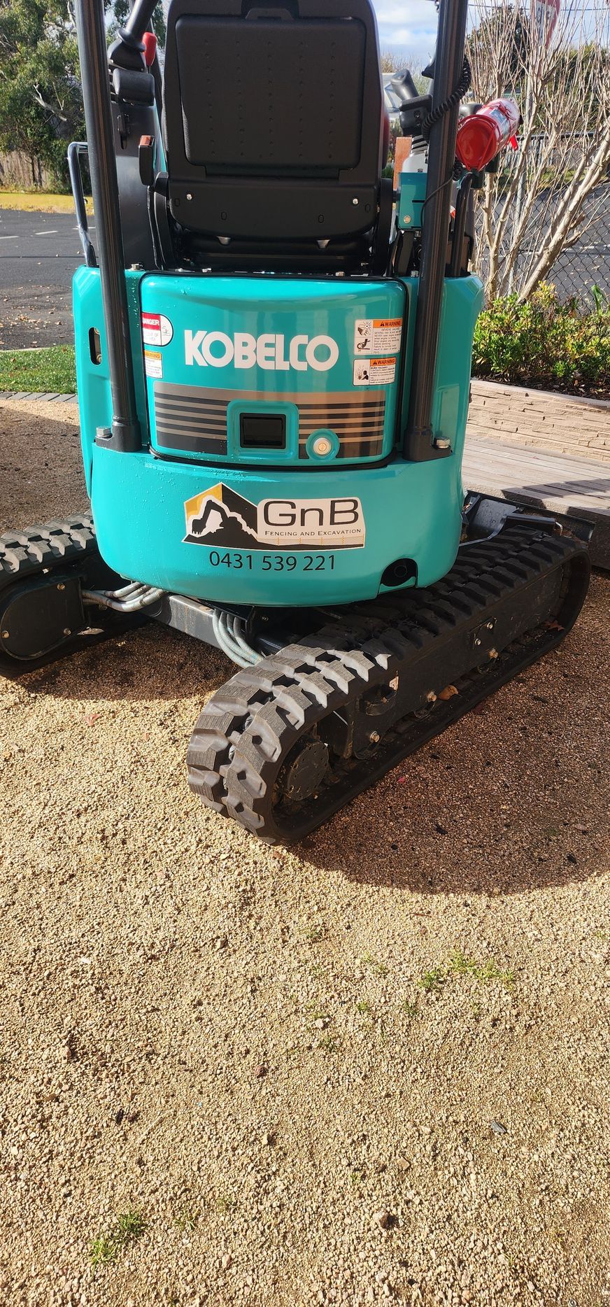 A Black Fence Is Sitting in The Middle of A Dirt Field  — GnB Fencing and Excavation in Queanbeyan, NSW