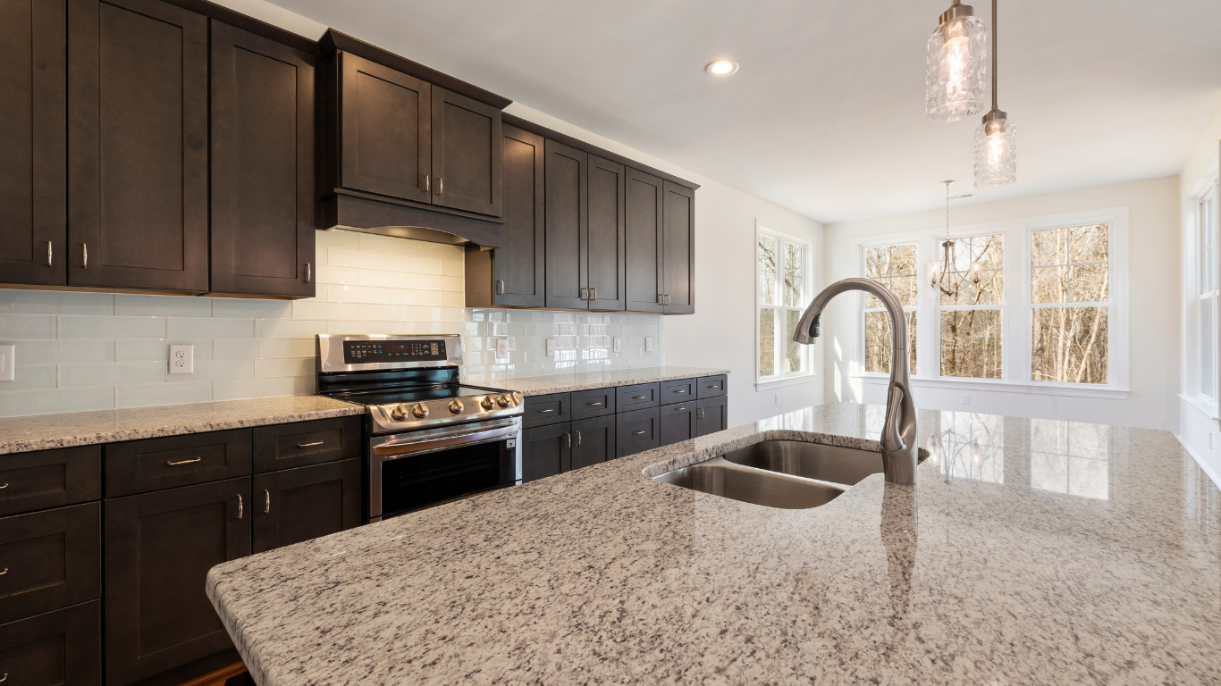 Kitchen with dark brown cabinets, granite countertops, and stainless steel appliances.