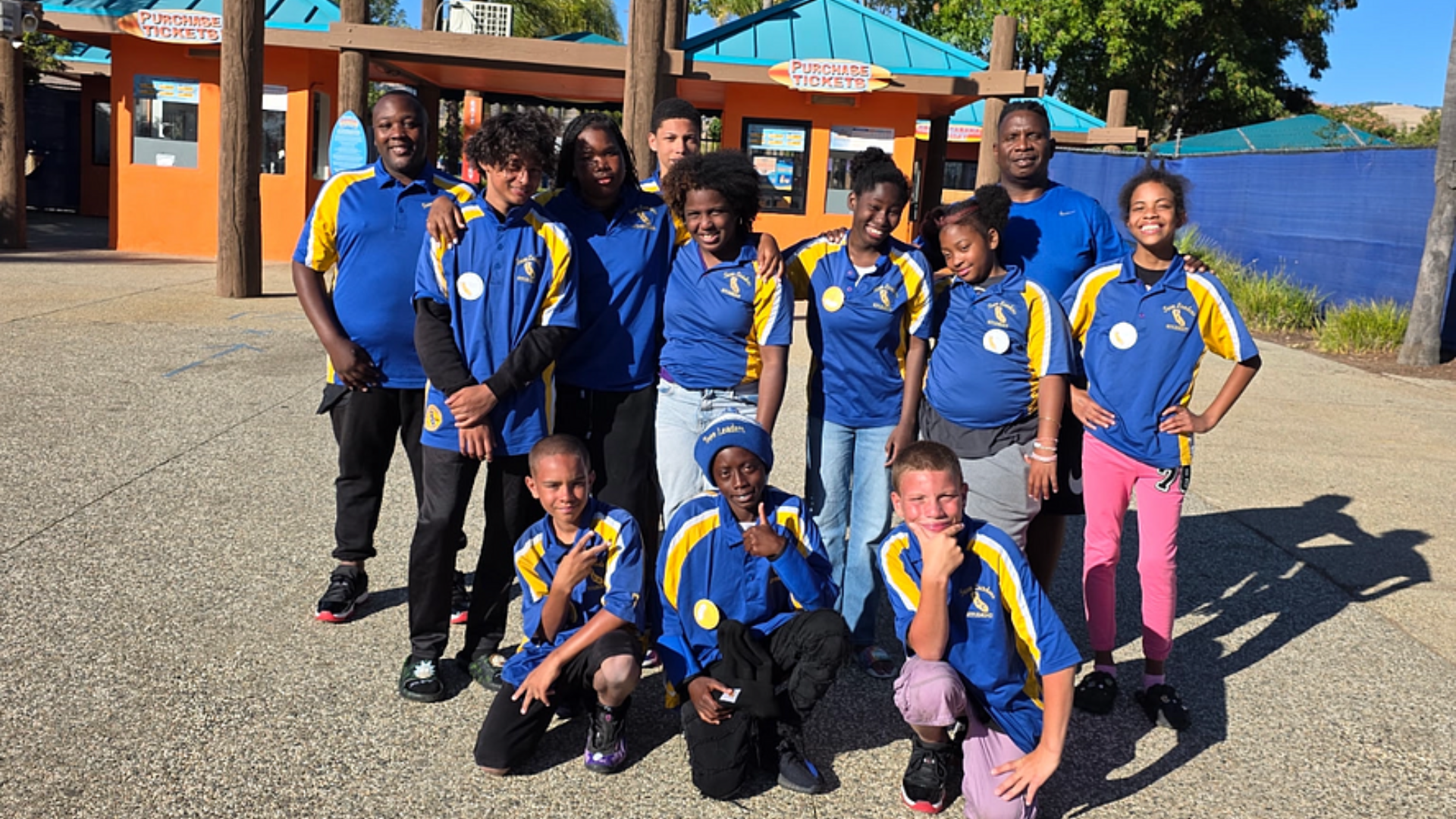 A group of people in blue and yellow shirts are posing for a picture.