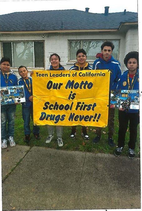 A group of young people holding a sign that says our motto is school first drugs never