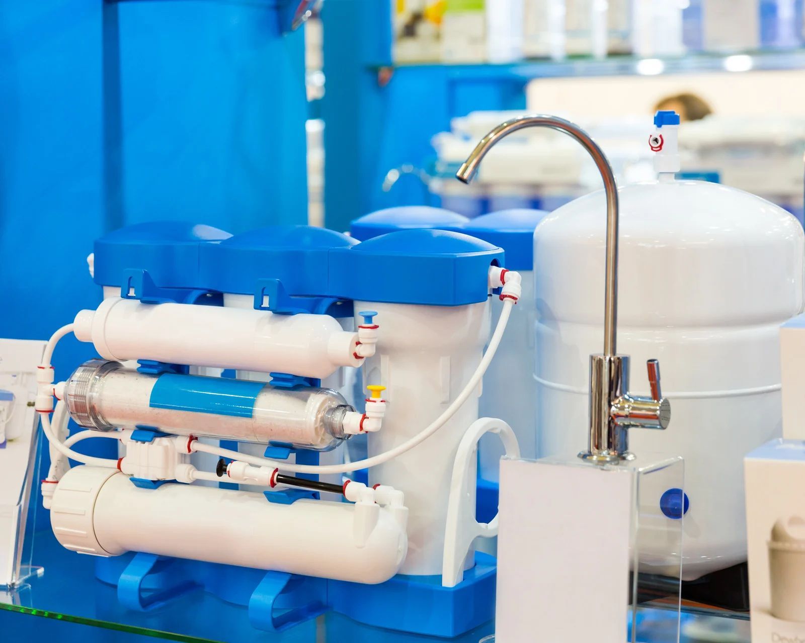 Blue and white water filtration system with a silver faucet in a store display.
