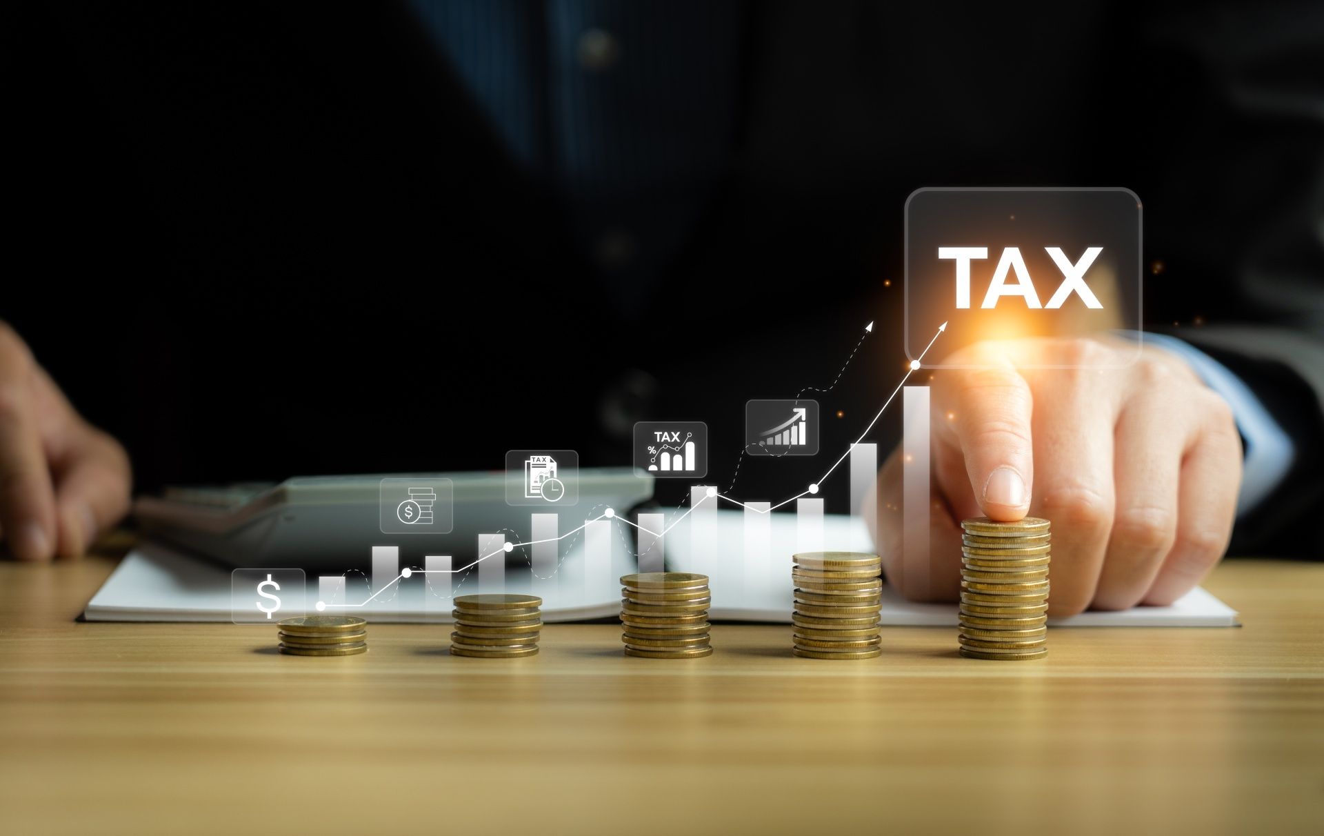 A person is stacking coins on a table and pressing a button that says tax.