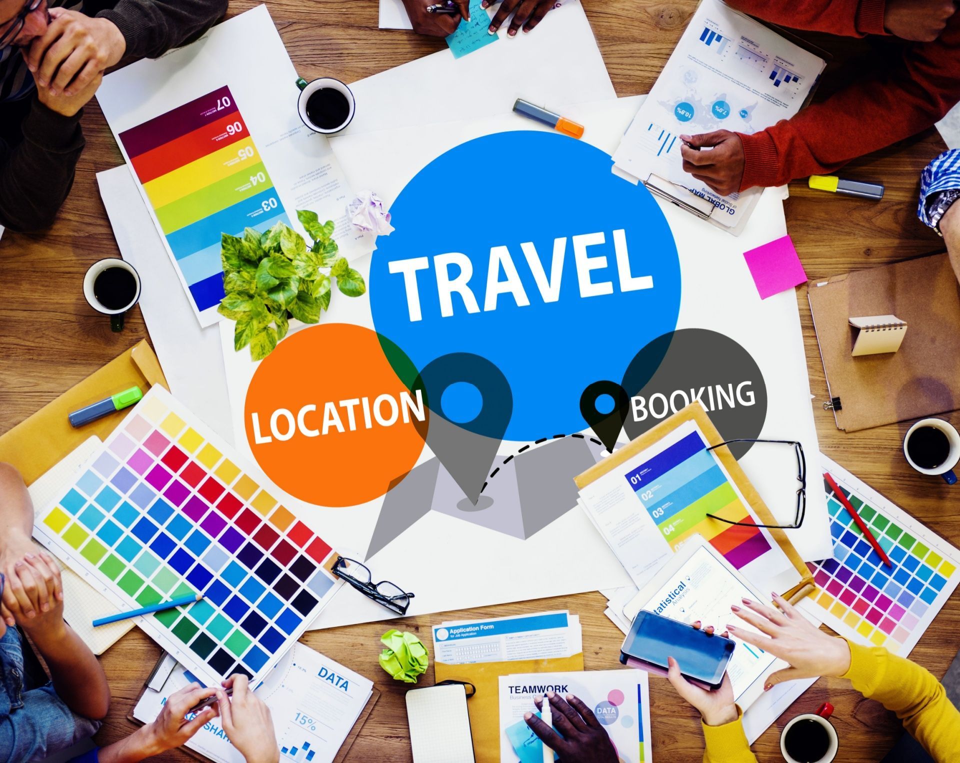 People collaborating around a table with travel-themed design elements, color palettes, and the words 