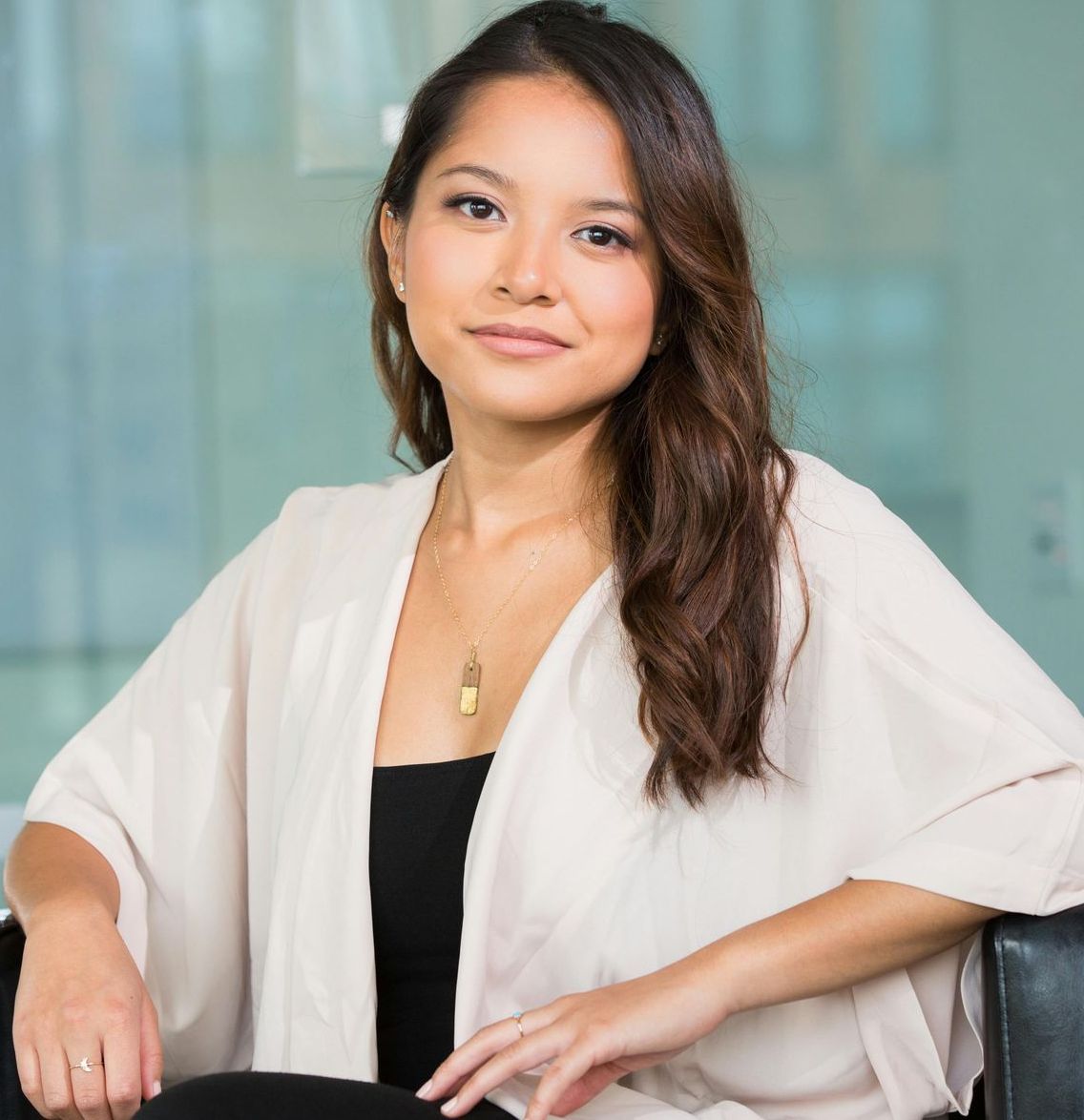 A woman in a white cardigan is sitting in a chair