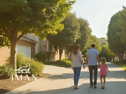 Family walking down a suburban street, holding hands. Sunny day, trees lining the sidewalk.