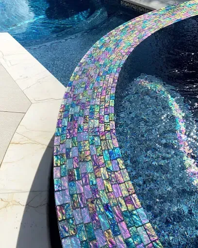 A close up of a swimming pool with a rainbow tile border.
