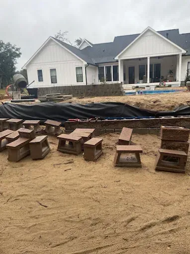 A house is being built with a lot of wooden benches and tables in front of it.