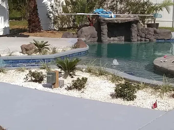 A large swimming pool with a waterfall in the middle of it