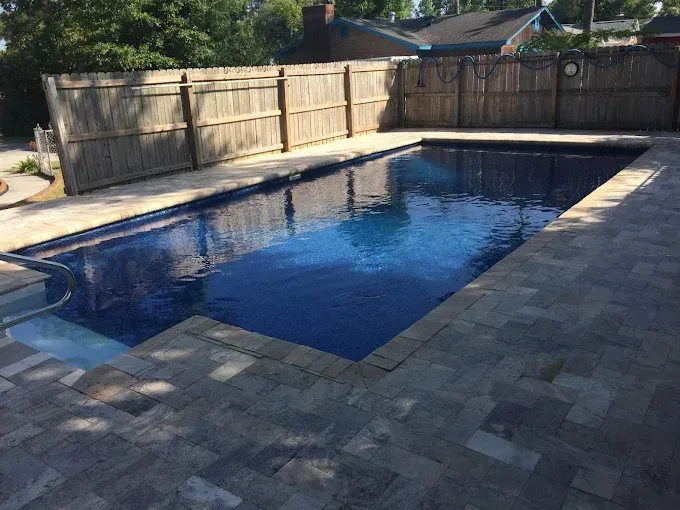 A large swimming pool with a wooden fence surrounding it