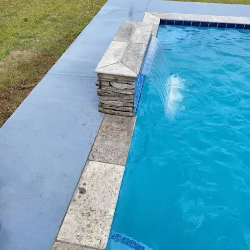 A swimming pool with a waterfall in the middle of it.