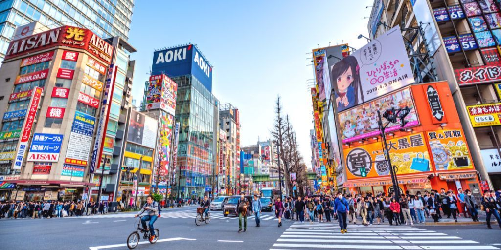 Una multitud de personas cruza una calle en una ciudad. en japon barrio akihabara en tokio