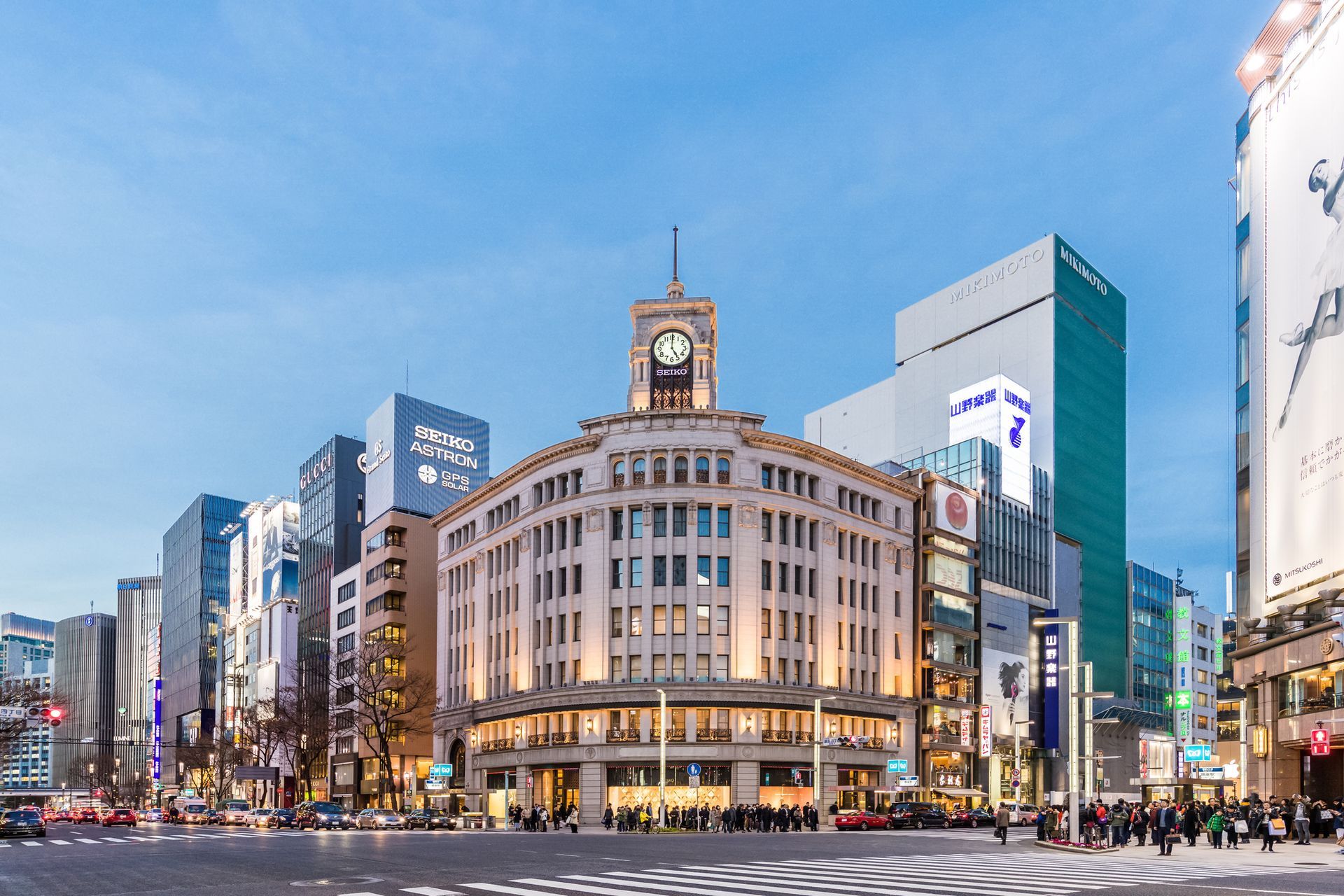 Un gran edificio con un reloj encima está en el medio de una ciudad. ciudad tokio viajar japon 