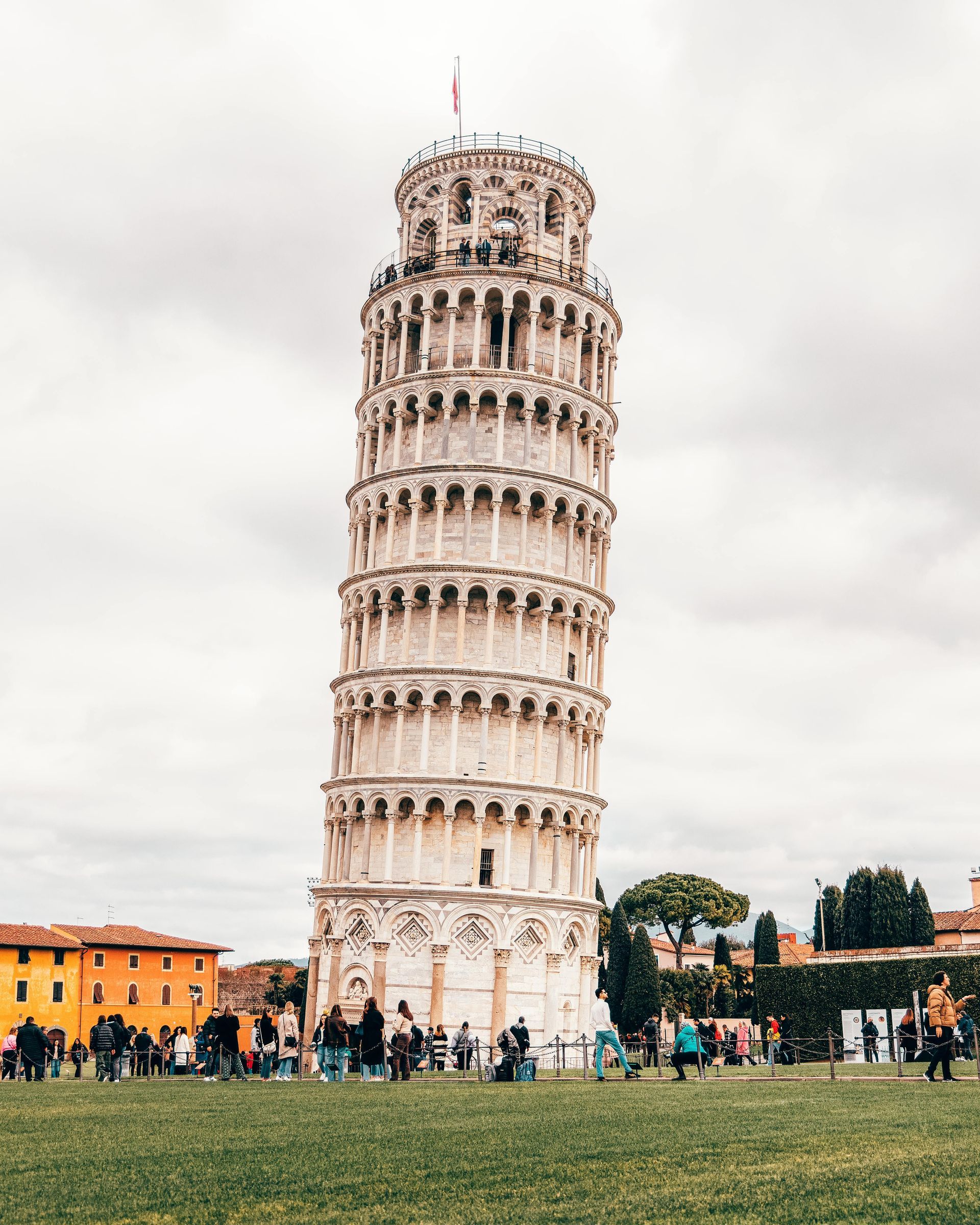 La Torre Inclinada de Pisa, Italia, está rodeada de césped y gente. La toscana