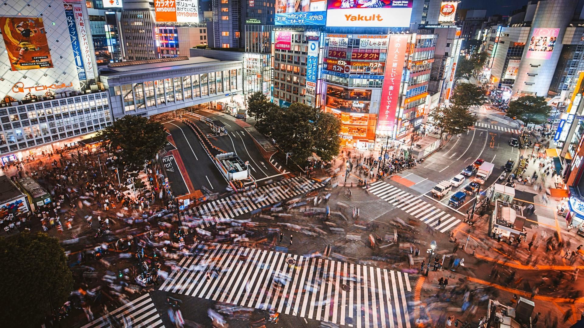 Una vista aérea de una intersección concurrida de la ciudad por la noche. en japon shibuya tokio