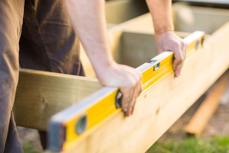 A man is using a level to check the level of a piece of wood.