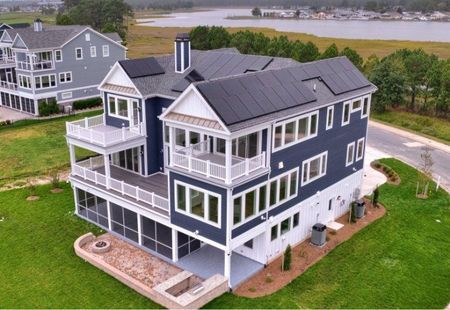 An aerial view of a large house with solar panels on the roof