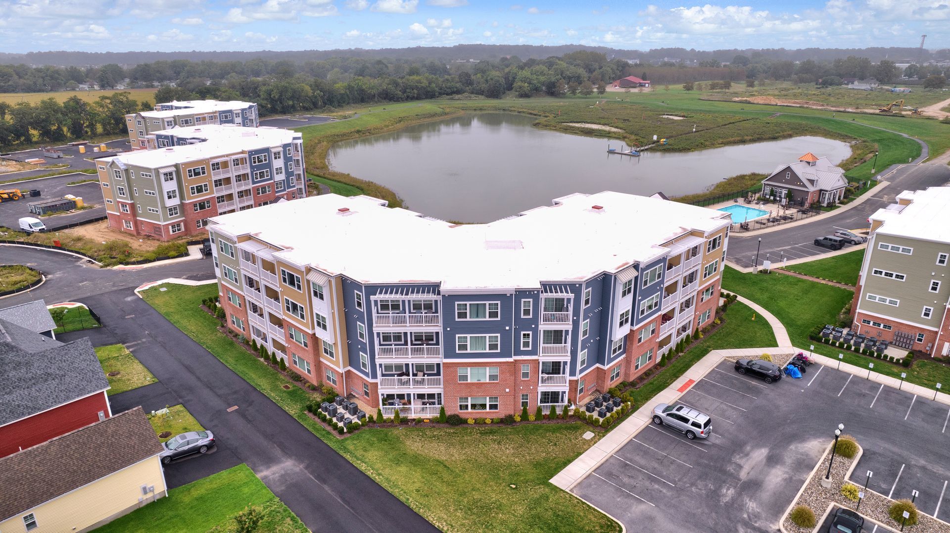 An aerial view of a apartment complex with a lake in the background