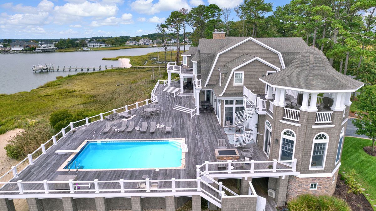 An aerial view of a large house with a large swimming pool.