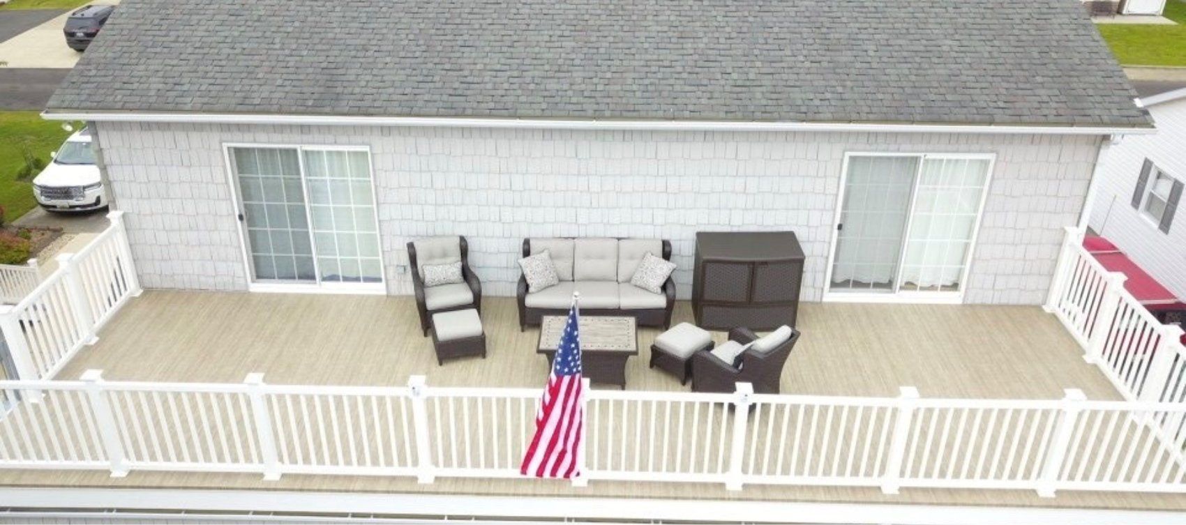 An aerial view of a house with a deck and patio furniture.